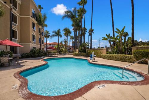 a swimming pool at a resort with palm trees at Best Western Escondido Hotel in Escondido
