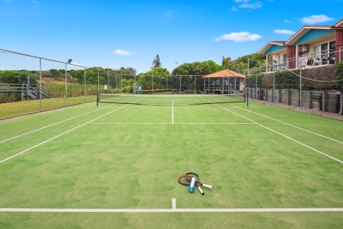 a tennis racket laying on a tennis court at Ocean View Apartment - Aqualuna Coffs Harbour in Sapphire Beach