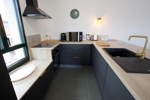 a kitchen with blue cabinets and a sink and a window at * Capbreton * T3 * Hypercentre * Plage * Famille in Capbreton