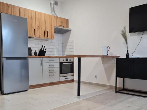 a kitchen with a refrigerator and a counter top at Apartamenty Pod Dachem in Lutowiska
