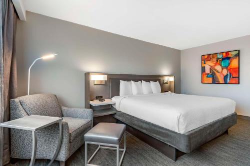 une chambre d'hôtel avec un lit et une chaise dans l'établissement Best Western Premier Rockville Hotel & Suites, à Rockville