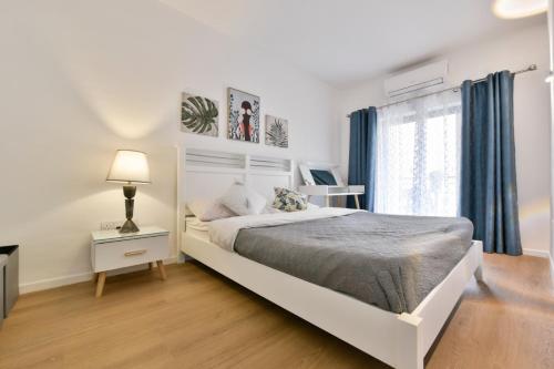 a white bedroom with a bed and a window at Mimosa Residenza in St. Julianʼs
