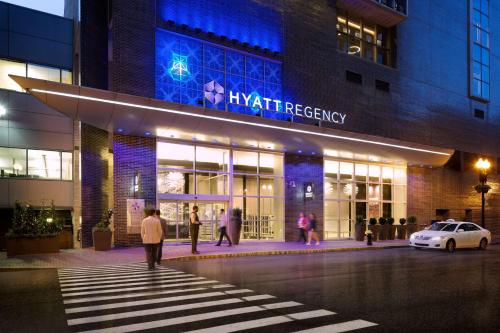 Un uomo che cammina di notte davanti a un palazzo di Hyatt Regency Boston a Boston