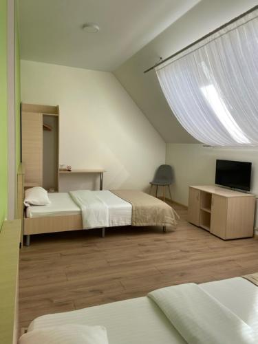 Hadyach的住宿－Готель Едем，一间卧室设有两张床、一台电视和一扇窗户。