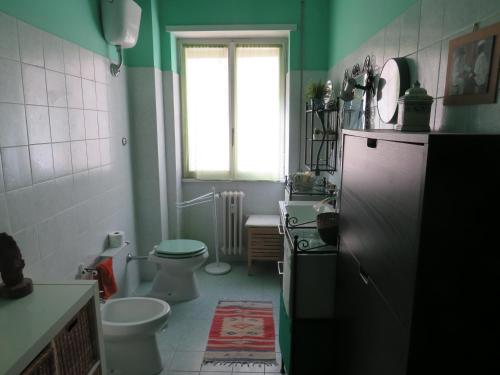 ein grünes Bad mit einem WC und einem Waschbecken in der Unterkunft Maddy House in Rom