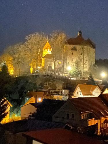 a large building in the background of a city at night at Schönes Doppelzimmer mit Küche und Badezimmer in Elgersburg