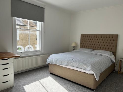 Un dormitorio con una cama grande y una ventana en 200m To Botanical Garden 3 Bedroom Victoria House, en Cambridge