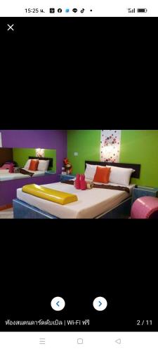 1 dormitorio con 2 camas de color verde y púrpura en โรงแรม โกแอ่นอินน์ รีสอร์ท เซอวิชอภาร์ทเม้นท์ en Surat Thani