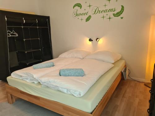 łóżko z dwoma poduszkami i znakiem, który czyta słodkie sny w obiekcie Lichtdurchflutetes Zimmer - Käppele w mieście Waldbüttelbrunn