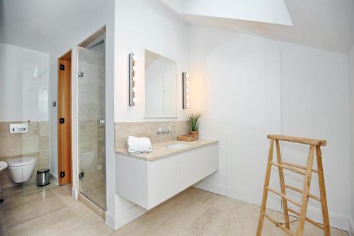 La salle de bains blanche est pourvue d'un lavabo et d'une douche. dans l'établissement Villa Greif Wohnung 05, à Heiligendamm