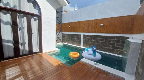 an indoor swimming pool with an inflatable at Roemah Renjana Rosie Makassar in Makassar