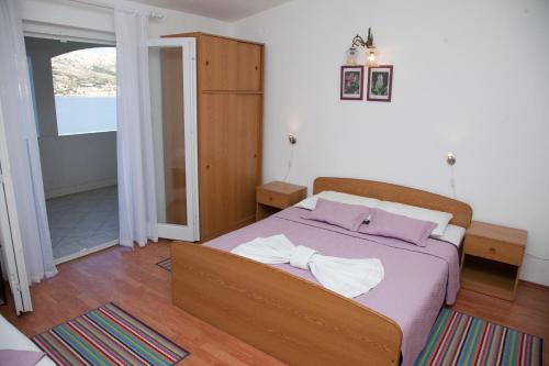 een slaapkamer met een bed met twee handdoeken erop bij First row to the sea apartment Azra in Pag