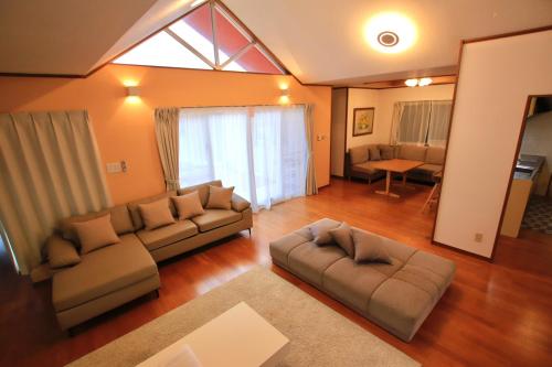 a living room with two couches and a couch at Guesthouse Akabana in Miyako-jima