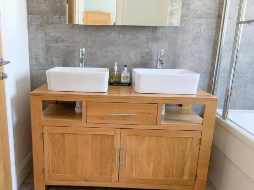 zwei Waschbecken auf einem Holzständer im Bad in der Unterkunft Muller residence in Bristol