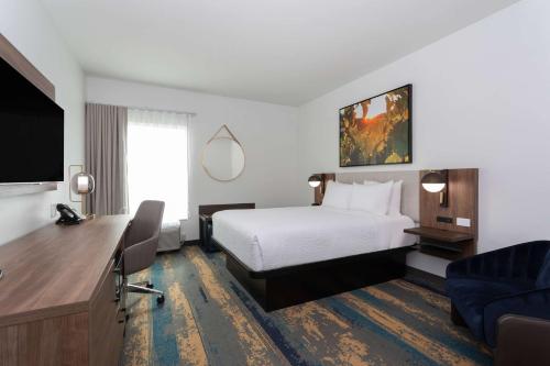 a hotel room with a bed and a flat screen tv at La Quinta Inn & Suites by Wyndham Galt Lodi North in Galt
