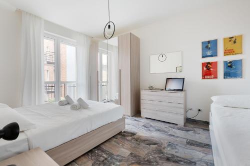 um quarto branco com uma cama e uma televisão em Dergano Comfy Apartment - 250 m far from M3 em Milão