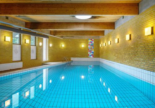 uma grande piscina num quarto grande em Hotel Menstrup Kro em Menstrup