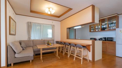 a living room with a couch and a table at Guesthouse Akabana in Miyako-jima