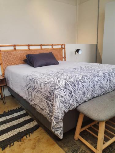 a bedroom with a bed with a blue pillow and a chair at LM Loft Maboneng in Johannesburg