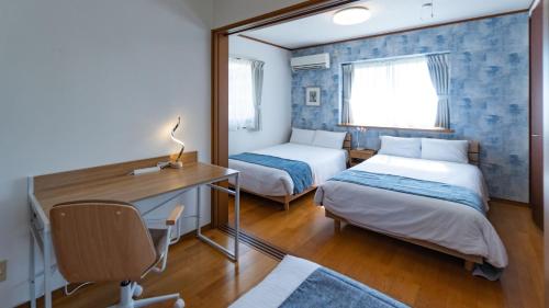 宮古島にあるゲストハウス あかばなのベッドルーム1室(ベッド2台、デスク、鏡付)