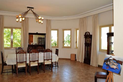 a dining room with a table and chairs and a clock at Villa Maria υπέροχη βίλα στα Μετέωρα in Kalabaka