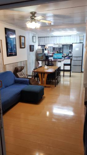 a living room with a blue couch and a table at 宮古島ゲストハウス　マウイ in Arazato