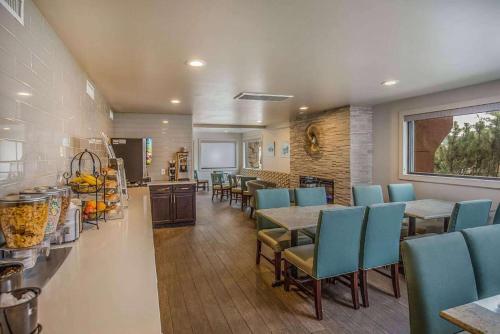 a dining room with blue chairs and tables and a kitchen at Baymont by Wyndham Durango in Durango