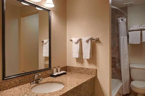 a bathroom with a sink and a toilet and a mirror at Baymont by Wyndham Durango in Durango