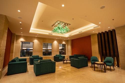 a waiting room with green chairs and a chandelier at Ratnamouli Palace in Guwahati