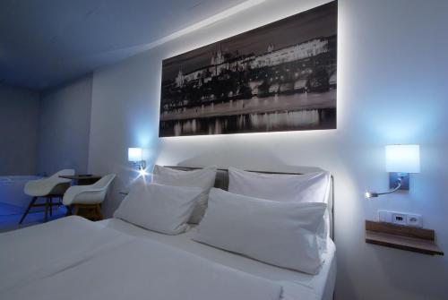 a bedroom with a white bed with white pillows at Adeba Plus in Prague