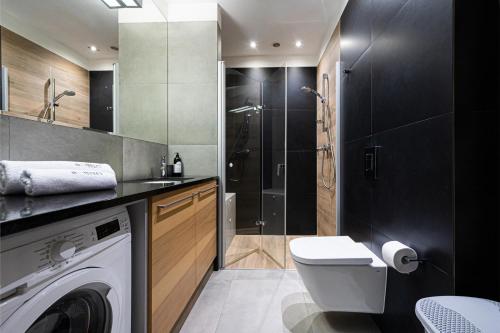a bathroom with a washing machine and a shower at Baltiq Plaza - BillBerry Apartments in Gdynia