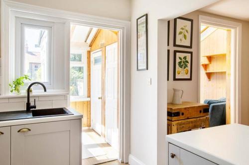 uma cozinha com um lavatório e uma porta aberta em Broadstairs Family Home em Kent