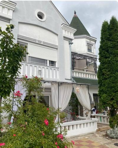 a white house with flowers in front of it at Vila Kraljica in Vrdnik