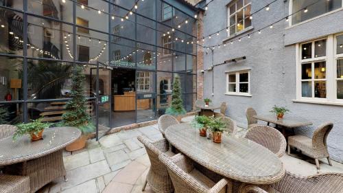 a patio with tables and chairs and a building at Hotel du Vin Bristol in Bristol