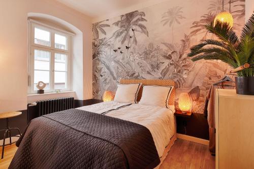 1 dormitorio con 1 cama con papel pintado tropical en Chase Apartments-Boutiquehotel Style II, en Würzburg