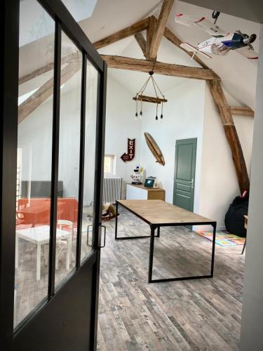 une chambre avec une table au milieu d'une pièce dans l'établissement Maison Héléna by hellofriends, au vert, piscine, padel, à Lain