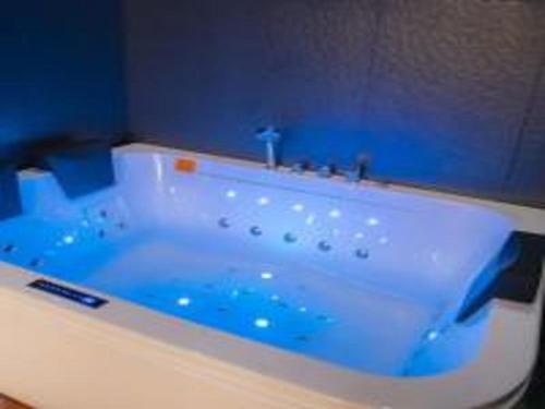 El baño incluye bañera blanca con agua azul. en نزل السلطان للأجنجة الفندقية en Jazan