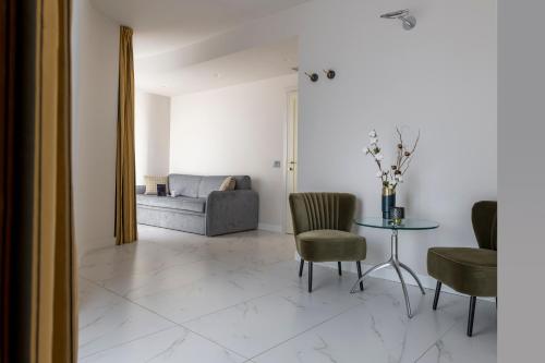 a living room with a couch and a table and chairs at Savoia Hotel Rimini in Rimini