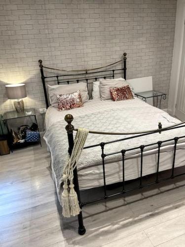 a bed in a bedroom with a brick wall at The Cabin, Arkley, Barnet in Barnet