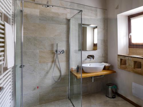 uma casa de banho com uma cabina de duche em vidro e um lavatório. em Agriturismo Cascina Margherita em Brescia