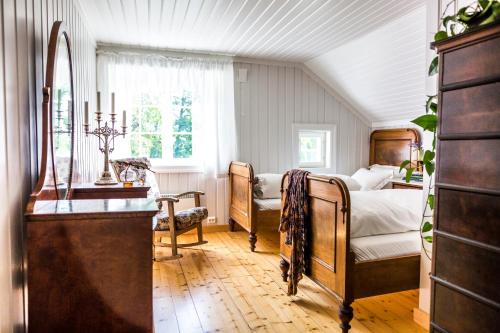 an attic bedroom with a bed and a dresser at Herregården Hoel - De Historiske in Nes i Ådal