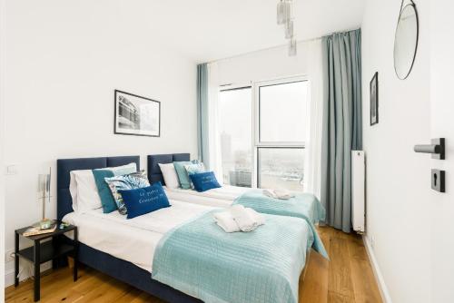 two beds in a room with a window at 16th Floor Towarowa 39 City Center Avenida by Renters Prestige in Poznań