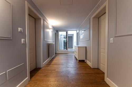 a hallway with wooden floors and white walls at Spazio San Marco in Bergamo