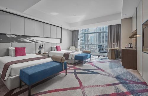 マニラにあるCrowne Plaza Manila Galleria, an IHG Hotelのベッド2台とデスクが備わるホテルルームです。