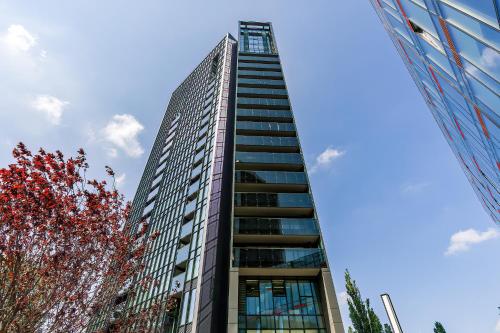 un edificio alto con un cielo blu sullo sfondo di 16th Floor Towarowa 39 City Center Avenida by Renters Prestige a Poznań