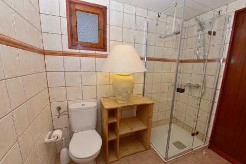 uma casa de banho com um WC e um candeeiro sobre uma mesa em Costamar 13 em Es Pujols