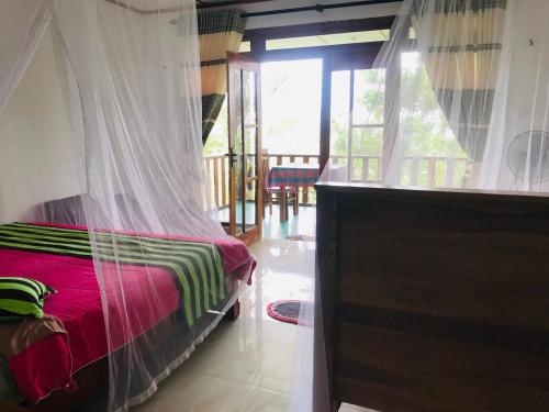 um quarto com uma cama e uma rede mosquiteira em Felicity Inn em Ella