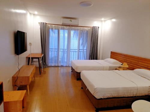 a hotel room with two beds and a television at sunny islander diving resort in Looc