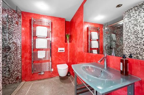 a red bathroom with a sink and a toilet at Malostranská Residence in Prague