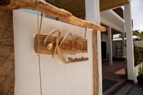 a sign on the side of a house at Kudhi Boli Beach House in Thulusdhoo